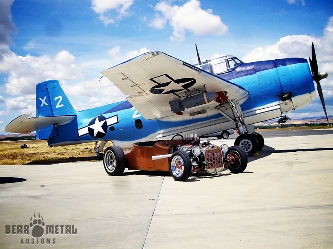 The roadster in front of a WW2 fighter.
